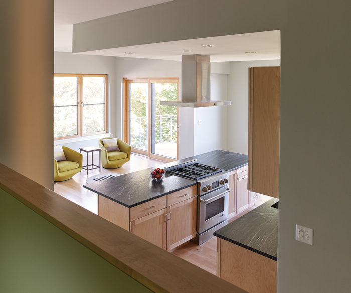 A view from a platform room at 118 on Munjoy Hill looks over the kitchen and living space to the windows beyond. 